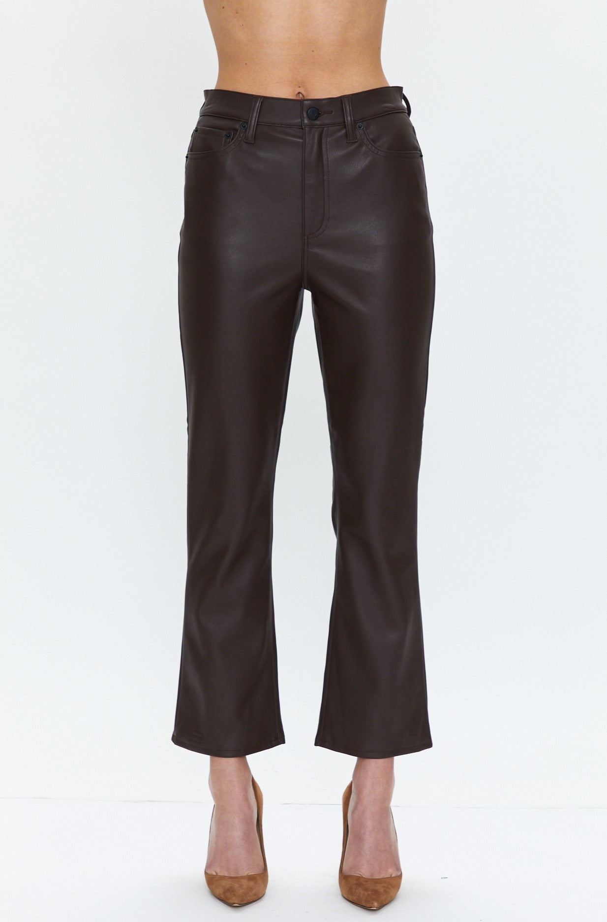 A person wearing the Pistola Lennon High Rise Crop Boot in Coffee Bean—a pair of high-waisted, cropped bootcut pants—styled with tan high heels, standing against a plain white background.