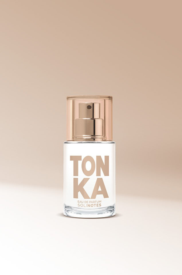 A clear glass perfume bottle labeled "Mini Tonka 15ml EDP" with a gold cap and Solinotes branding sits on a neutral beige background, displaying Eau de Parfum in small text.