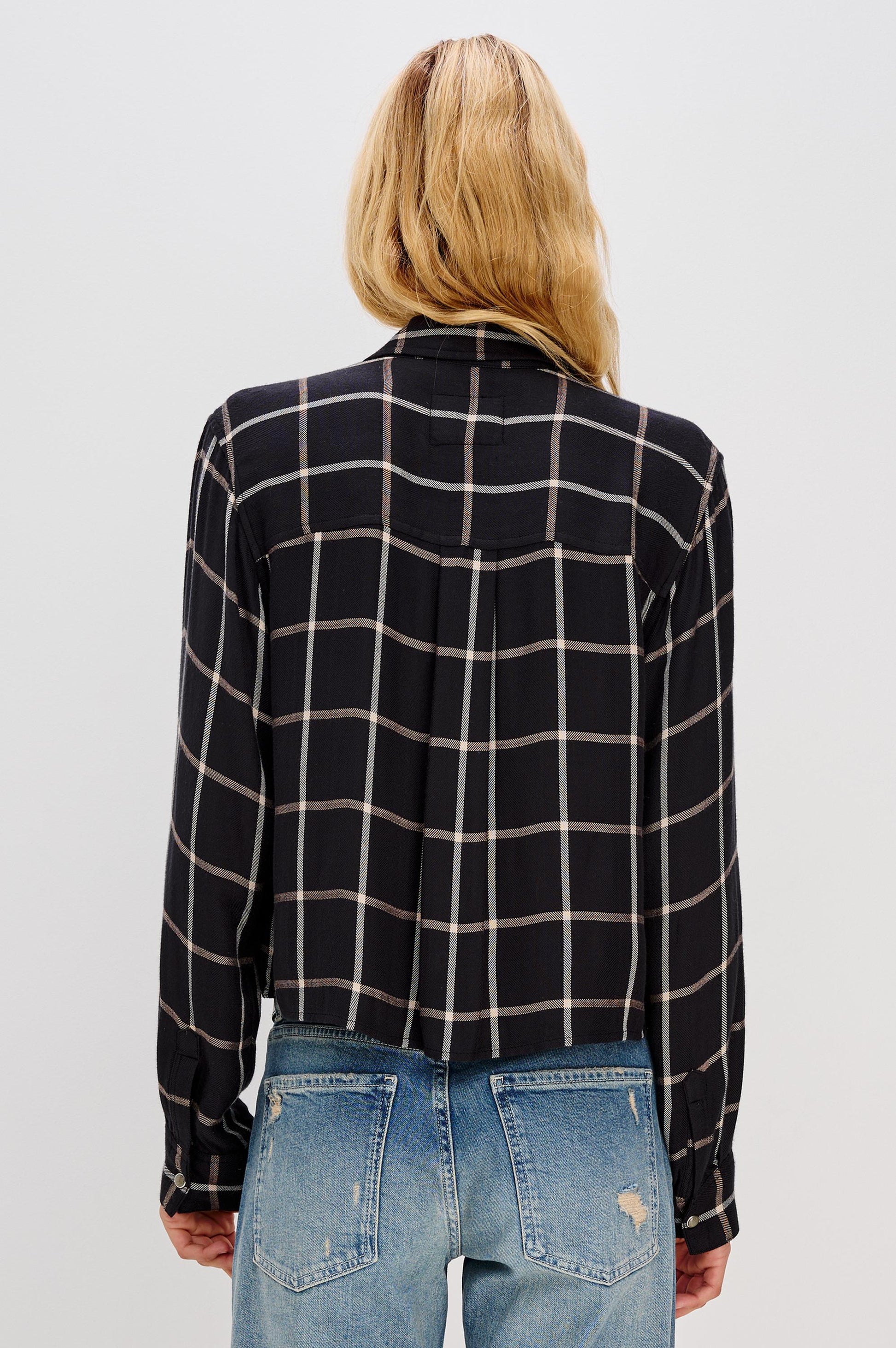 A person with long blonde hair, shown from the back in a relaxed fit Malin Long Sleeve Check shirt by Rails and blue distressed jeans, against a light background. Crafted from 100% rayon; hand wash cold recommended.