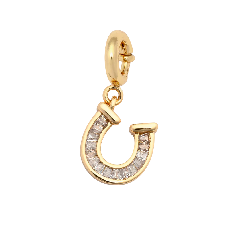 Little Words Project's Charm - Horseshoe features a gold, horseshoe-shaped pendant with clear gemstones and a small gold loop for easy attachment to a necklace or bracelet, displayed on a plain white background.