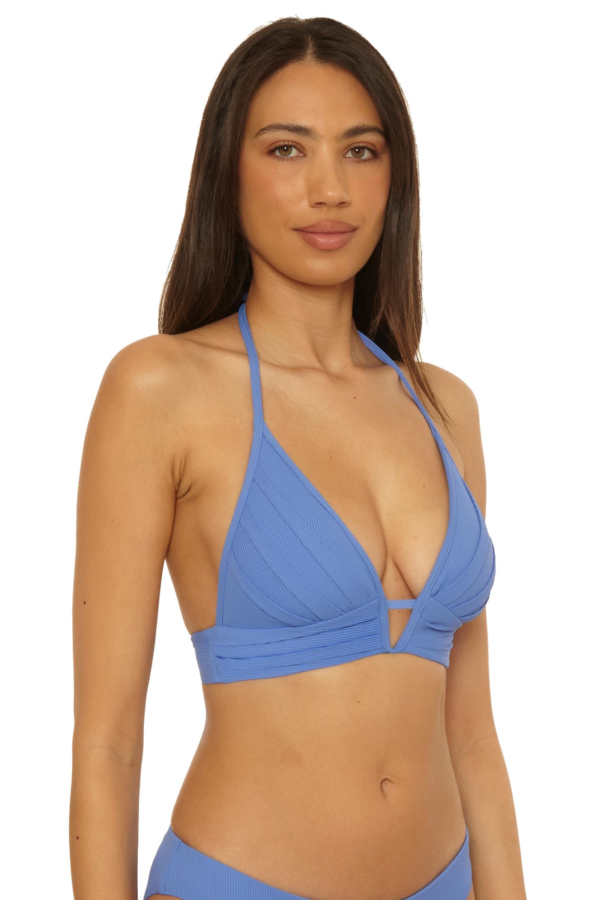 A woman with long dark hair wears the Becca Swim Modern Edge Halter in Coastal, featuring removable soft cups and a deep V neckline, as she stands against a plain white background.