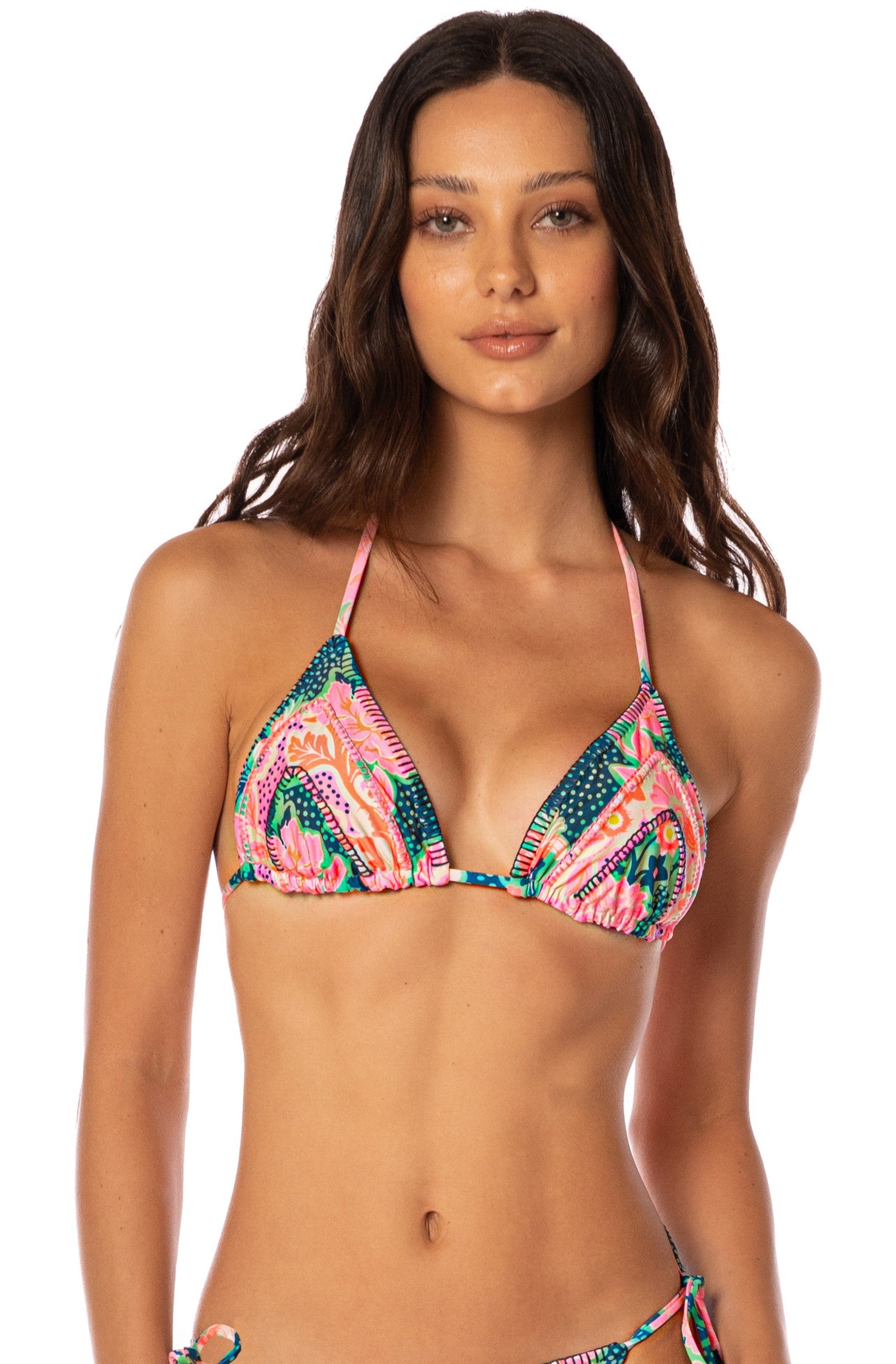A woman with long brown hair wears the Maaji Blush Floral Alana Top, a colorful bikini featuring pink, blue, green, and orange designs. She stands against a plain white background, looking at the camera with a neutral expression.