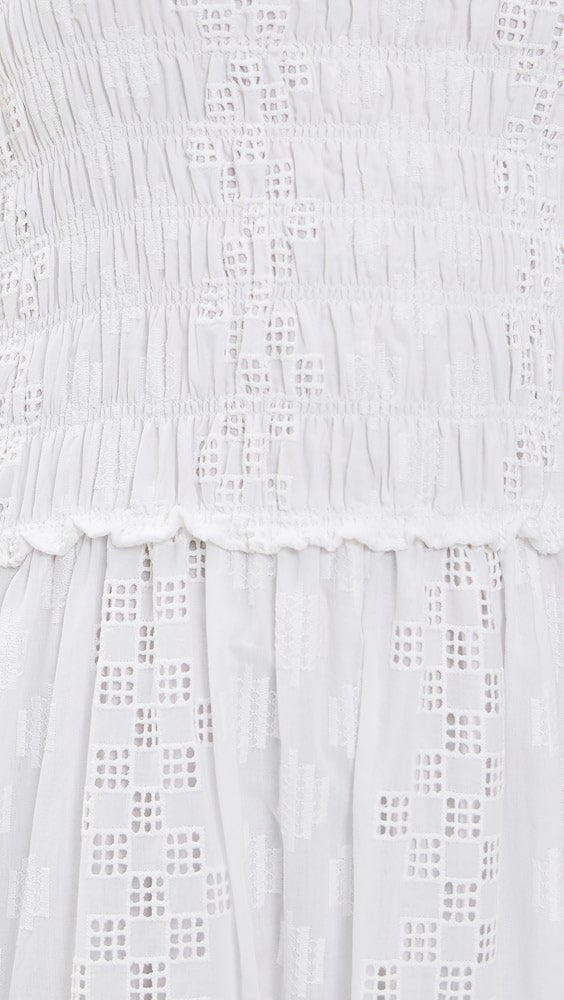 Close-up of the Splendid Kendra Geo Eyelet Dress, featuring textured smocking on white fabric above a geometric eyelet pattern with small square cut-outs.
