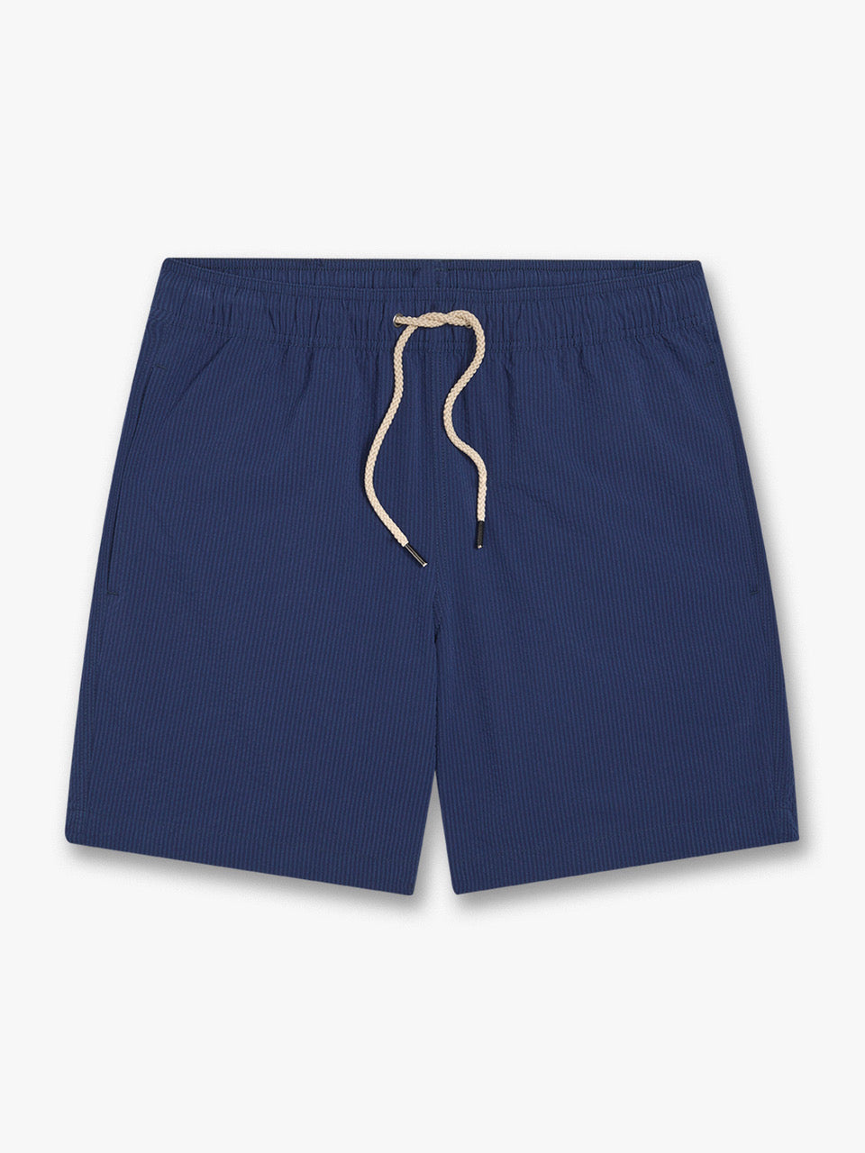 Fair Harbor's Bayberry Trunk 7 Inch Navy Seersucker features subtle pinstripes, an elastic waistband with cream drawstring, side pockets, and a built-in liner, displayed flat against a white background.